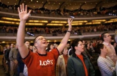 A parishioner cries as he signs a song of worship in the 7,000-seat Willow Creek Community church during a Sunday service in South Barrington, Illinois. Institutions like Willow Creek and Houston's Lakewood Church, each drawing 20,000 or more on a weekend