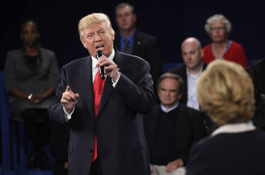 Republican U.S. presidential nominee Donald Trump speaks as Democratic U.S. presidential nominee Hillary Clinton (R) listens during their presidential town hall debate at Washington University in St. Louis, Missouri, U.S., October 9, 2016.