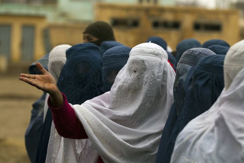 An Afghan woman reacts as she waits in a line to vote at a polling station in Mazar-i-Sharif April 5, 2014.