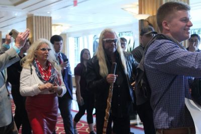Duane "Dog the Bounty Hunter" Chapman walks with his wife, Beth, as they are surrounded by fans at the Gaylord National Resort and Convention Center in Oxon Hill, Maryland on Feb.24, 2017.