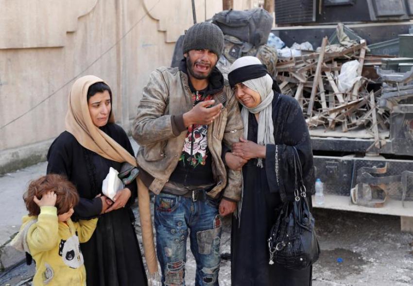 People who are trying to escape fighting between Iraqi forces and Islamic State fighters cry on a street in Mosul in June 2017.