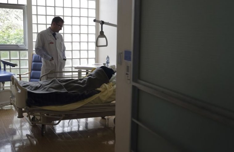 Doctor Stephane Mercier visits a patient at the palliative care unit of the AP-HP Paul-Brousse hospital in Villejuif near Paris. | Reuters