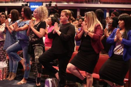 Women at Potter's House Dallas engage in yoga exercises on Aug. 4, 2018.