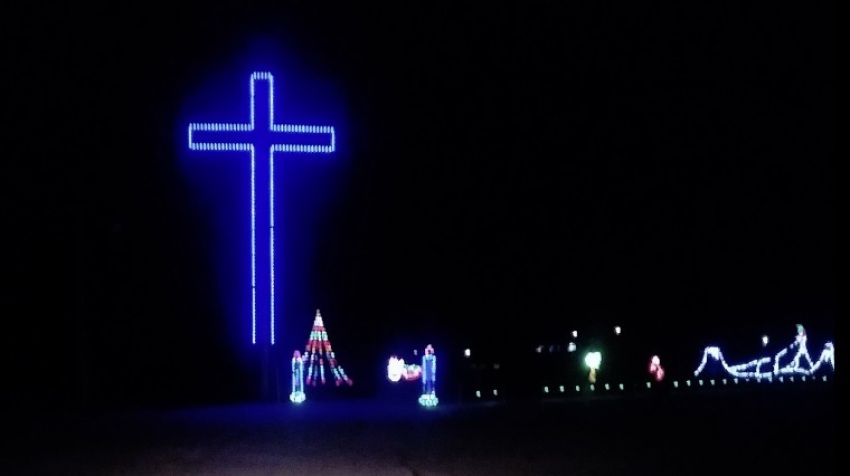 A blue-lit cross stands erect as part of a Christmas light display at Finley River Park in Ozark, Missouri in December 2018.