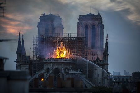 Smoke and flames rise from Notre-Dame Cathedral on April 15, 2019 in Paris, France. A fire broke out on Monday afternoon and quickly spread across the building, collapsing the spire. The cause is yet unknown but officials said it was possibly linked to ongoing renovation work.