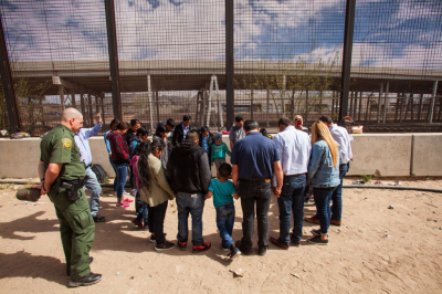 A group of evangelical pastors pray with a group of 22 migrants from Honduras, Guatemala and Salvador underneath the Paso Del Norte Bridge where they are being held for processing in El Paso, Texas, on March 28, 2019.