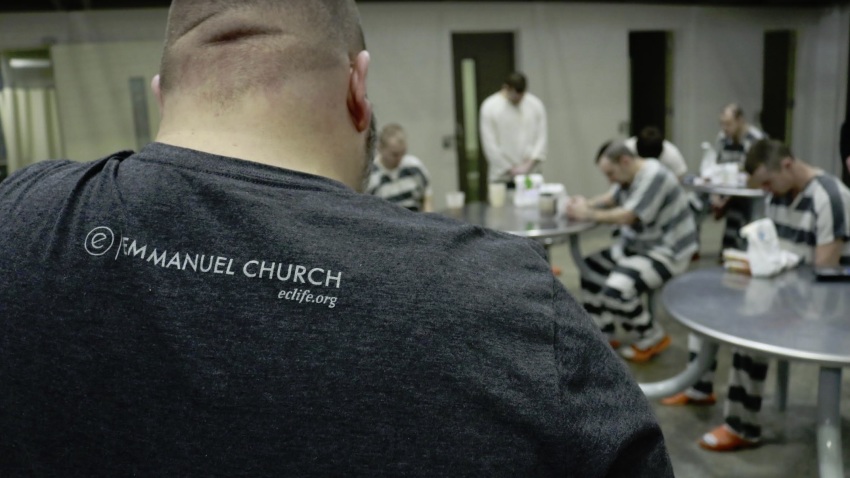 Inmates at Brown County Jail in Indiana pray after receiving care kits given to them by Emmanuel Church.