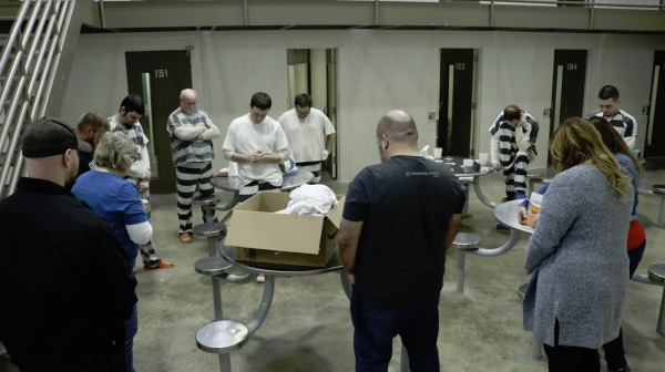 Inmates at Brown County Jail in Indiana pray after receiving care kits given to them by Emmanuel Church.