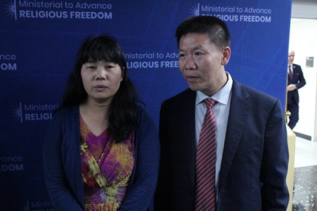 Manping Ouyang (L), a Chinese Christian who belongs to the Living Stone Church in Guiyang, speaks with reporters during the U.S. State Department's Ministerial to Advance Religious Freedom at the Harry S. Truman Building in Washington, D.C. Her remarks were translated by Bob Fu (R) of China Aid.