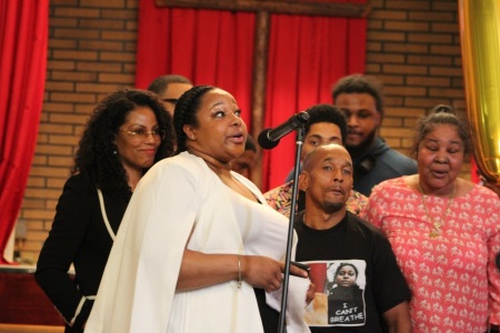 Emerald Garner speaks at the fifth anniversary of her father's death at Canaan Baptist Church in Harlem, New York, on July 30, 2019. She is joined by her brothers, Emery and Eric Garner Jr.; her mother, Esaw Snipes Garner (not pictured); Korey Wise, one of the exonerated Central Park Five; Ilyasah Shabazz (back left), daughter of Malcolm X, and actor, rapper, dancer Sean “ARNSTAR” Kirkland (back center).