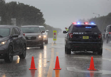 A Highland Beach police officer sits in his vehicle to check id's of people in cars as he only allows residents to enter the Highland Beach area as Hurricane Dorian continues to make its way toward the Florida coast on September 02, 2019 in Highland Beach, Florida.