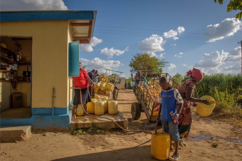 Collins Kiilu and his grandma, Sophia, fill up their jerrycans with water in Mwala, Kenya.
