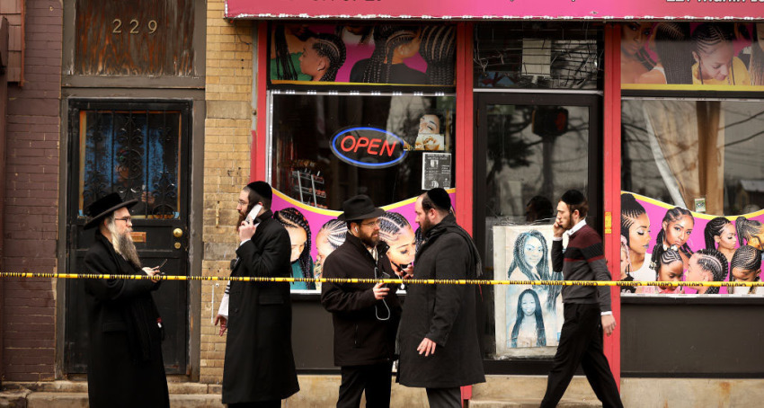 Members of the Jewish community pass by near the scene of a mass shooting at the JC Kosher Supermarket on December 11, 2019, in Jersey City, New Jersey. Six people, including a Jersey City police officer and three civilians were killed in a deadly, hours-long gun battle between two armed suspects and police on Tuesday in a standoff and shootout in a Jewish market that appears to have been targeted, according to Jersey City Mayor Steven Fulop.