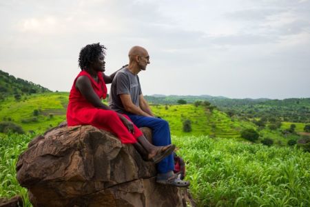 Dr. Tom Catena and his wife, Nasima Mohammed Bashir, sit on a rock in the Nuba Mountains of Sudan.