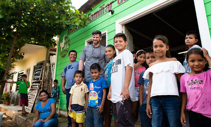 Edward Graham, assistant to the vice president of Operation Christmas Child, standing next to Jesús, (L), his family and children at the breakfast center where he serves in Mazatlan, Mexico, October 2019.