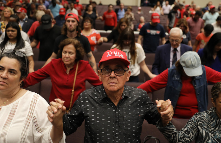 People pray together during the 'Evangelicals for Trump' campaign event held at the King Jesus International Ministry as they await the arrival of President Donald Trump on January 3, 2020, in Miami, Florida.