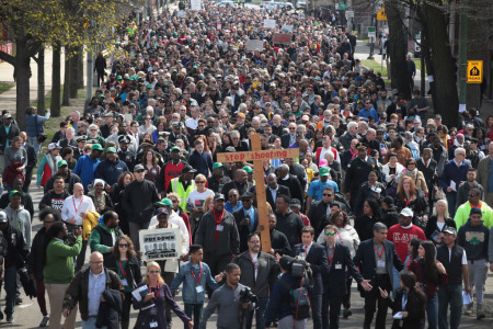Marchers, led by Cardinal Blase Cupich, walk through the Englewood neighborhood calling for an end to the violence that has plagued the city on April 14, 2017 in Chicago, Illinois. The marchers stopped several times to reflect on the Stations of the Cross and to read out the names of Chicago homicide victims. With 14 homicides so far in 2017, Englewood was one of the most violent neighborhoods in the city at the time.