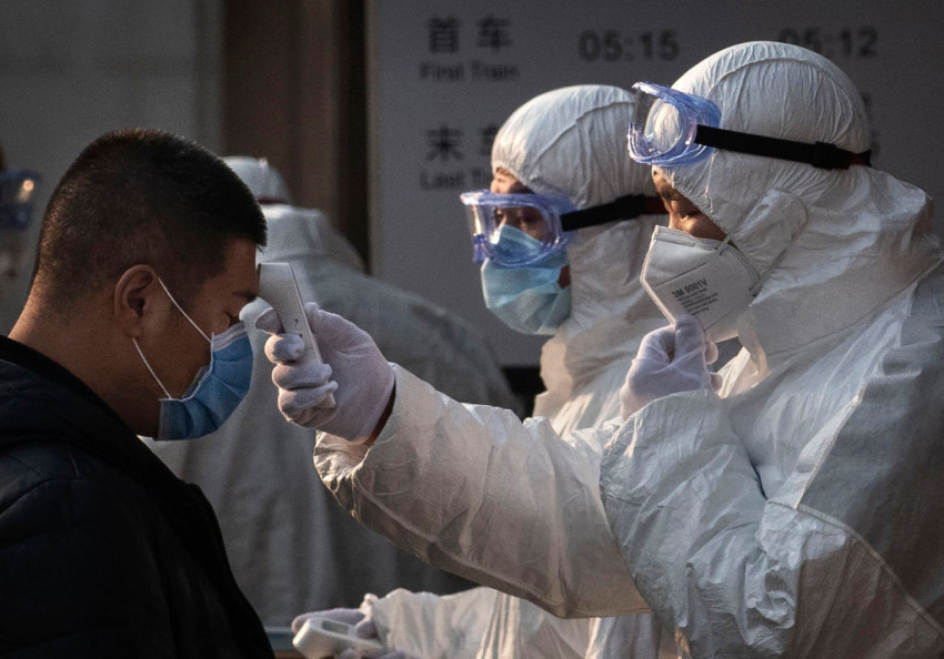 A Chinese health worker checks the temperature of a woman entering a subway station during the Chinese New Year and Spring Festival on January 25, 2020, in Beijing, China.
