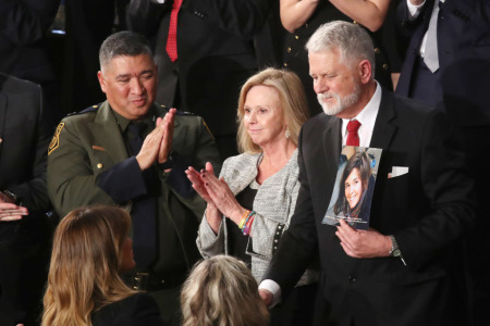 Carl Mueller (C) holds a photo of his daughter, Kayla, as his wife, Marsha, (L) looks on during the State of the Union address in the chamber of the U.S. House of Representatives on February 04, 2020, in Washington, D.C.