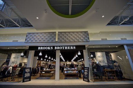 Sale signs stand on display outside of a Brooks Brothers store at the Tsawwassen Mills Outlet Shopping Mall in British Columbia, Canada.