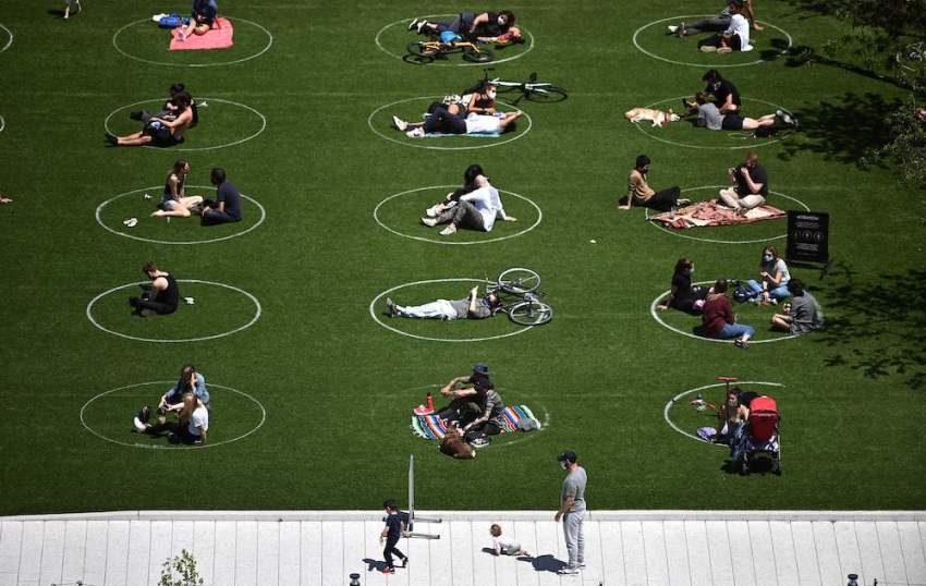 People are seen practicing social distancing in white circles in Domino Park during the COVID-19 pandemic on May 17, 2020, in the Brooklyn borough of New York City.
