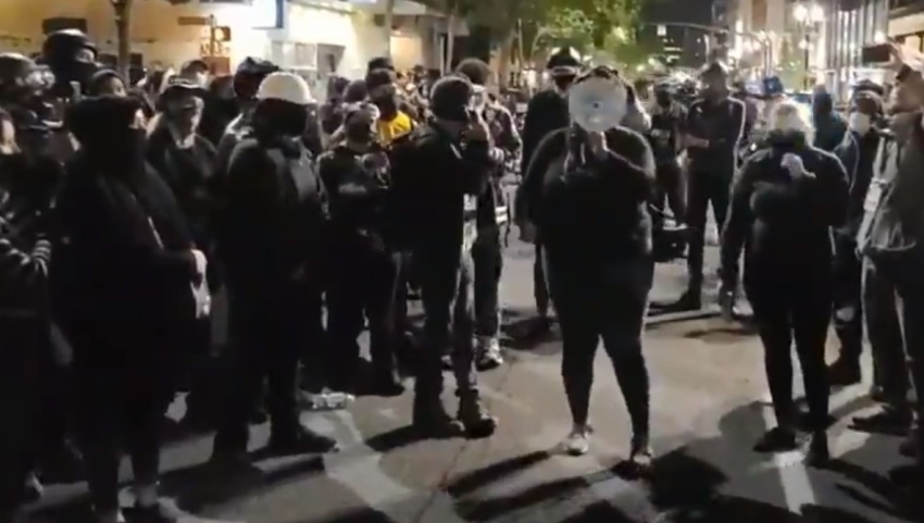 An activist speaks through a megaphone in the streets of Portland, Oregon after the killing of Aaron Danielson on Aug. 29, 2020.