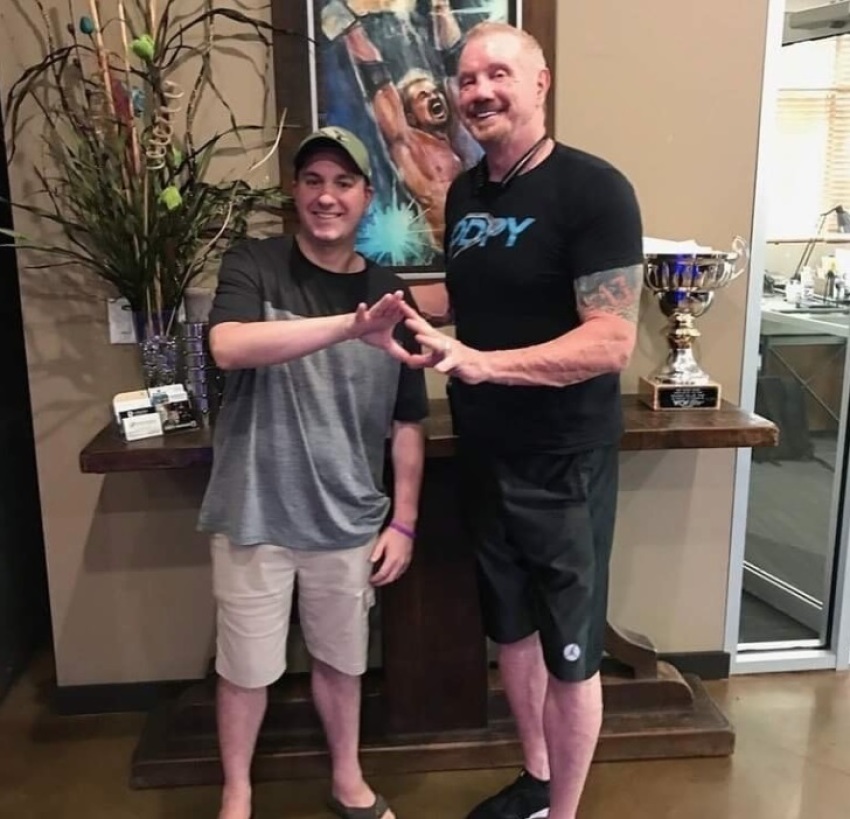 Brandon Berry (L) poses for a photograph with former professional wrestler Diamond Dallas Page (R) at the DDP Yoga Performance Center in Smyrna, Georgia in August 2019.