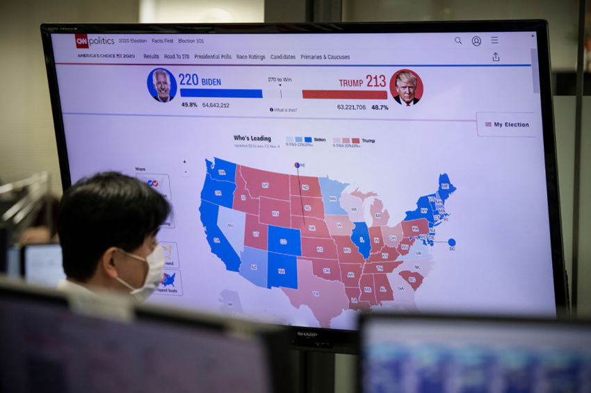 A foreign exchange trader monitors screens as results are broadcast from the United States election, on November 4, 2020, in Tokyo, Japan. After a record-breaking early voting turnout, Americans head to the polls on the last day to cast their vote for incumbent U.S. President Donald Trump or Democratic nominee Joe Biden in the 2020 presidential election.