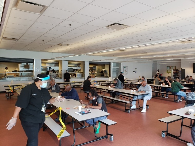Guests at A Safe Haven eat at a dining hall during COVID-19