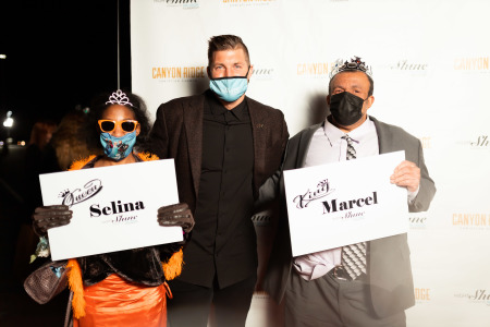 Tim Tebow poses with two individuals at the 2021 Shine-Thru prom event.