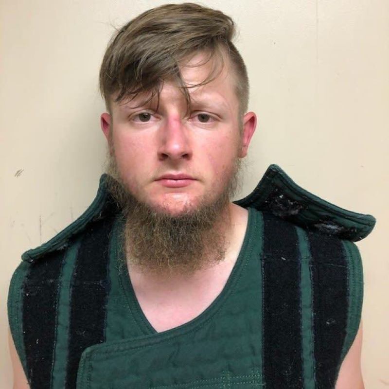 A man walks past a massage parlor where three women were shot and killed on March 17, 2021, in Atlanta, Georgia. Suspect Robert Aaron Long, 21, was arrested after a series of shootings at three Atlanta-area spas left eight people dead on Tuesday night, including six Asian women. | Elijah Nouvelage/Getty Images