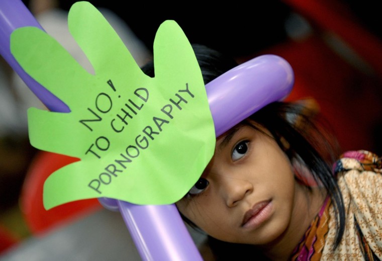 A grade school girl takes part in a Manila public forum on child pornography, also attended by United Nations officials and local movie actors in Manila on June 5, 2009. | Jay Directo/AFP via Getty Images