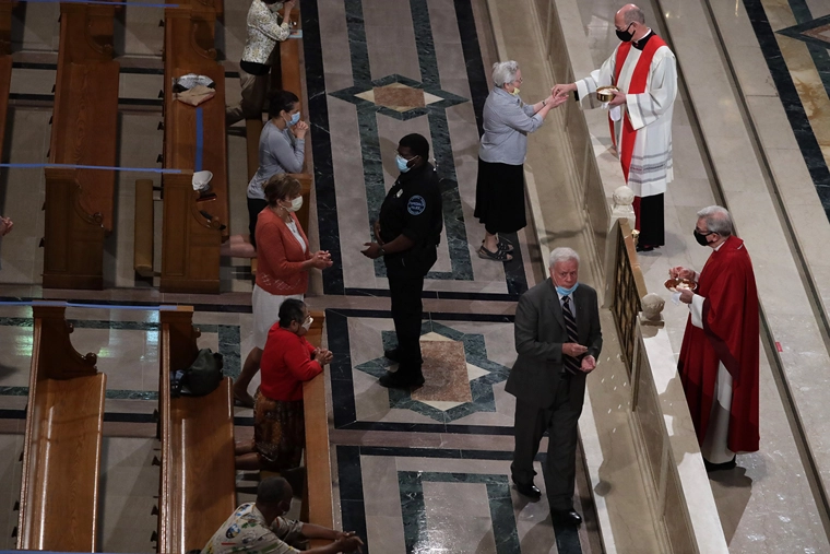 Members of the congregation take part in a communion with social distancing during a mass at the Basilica of the National Shrine of the Immaculate Conception June 22, 2020 in Washington, D.C. The government of District of Columbia has begun phase two of reopening due to the COVID-19 pandemic, with houses of worship resuming at maximum of 50% capacity, and no more than 100 people. | Alex Wong/Getty Images
