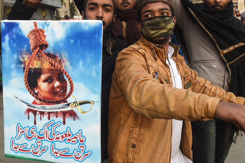 Pakistani Islamists hold a poster displaying the portrait of Asia Bibi, a Christian Pakistani woman accused of blasphemy, during a protest against the Supreme Court decision on Bibi's case in Lahore on February 1, 2019. As Islamist extremists announced fresh protests demanding her execution, officials said she was free to go abroad, with speculation rampant that she will seek asylum in Europe or North America.
