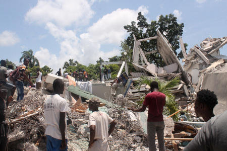 People search through the rubble of what used to be the Manguier Hotel after the earthquake hit on August 14, 2021, in Les Cayes, southwest Haiti. - Rescue workers scrambled to find survivors after a powerful 7.2-magnitude earthquake struck Haiti early Saturday, killing at least 304 and toppling buildings in the disaster-plagued Caribbean nation still recovering from a devastating 2010 quake. The epicenter of the shaking, which rattled homes and sent terrified locals scrambling for safety, was about 100 miles (160 kilometers) by road west of the center of the densely populated capital Port-au-Prince.