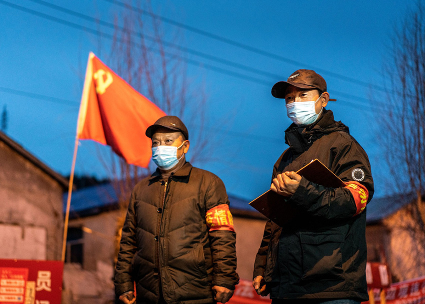 This photo taken on April 21, 2020, shows staff members keeping watch at a checkpoint in the border city of Suifenhe, in China's northeastern Heilongjiang province.