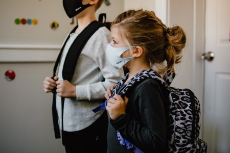 Two students are seen wearing masks over their faces.