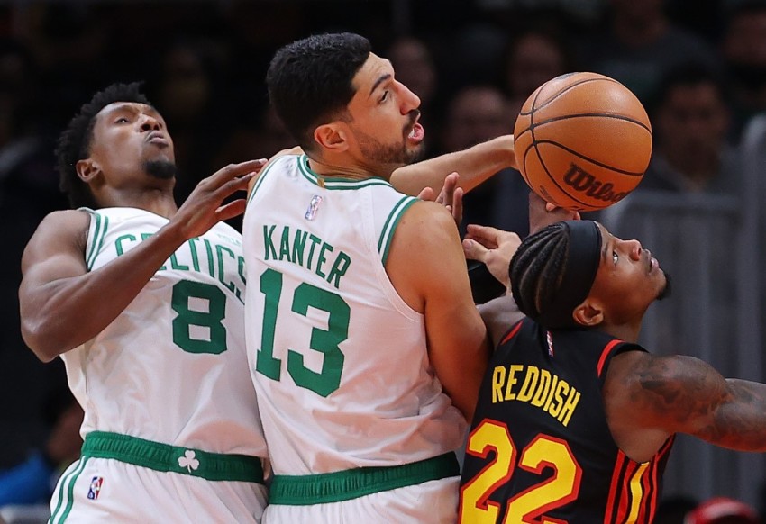 Cam Reddish #22 of the Atlanta Hawks battles for a rebound against Enes Kanter #13 and Josh Richardson #8 of the Boston Celtics during the first half at State Farm Arena on November 17, 2021 in Atlanta, Georgia.