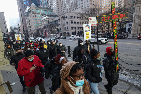 People walk during an anti gun violence march on the Magnificent Mile in Chicago, Illinois, on December 31, 2020.