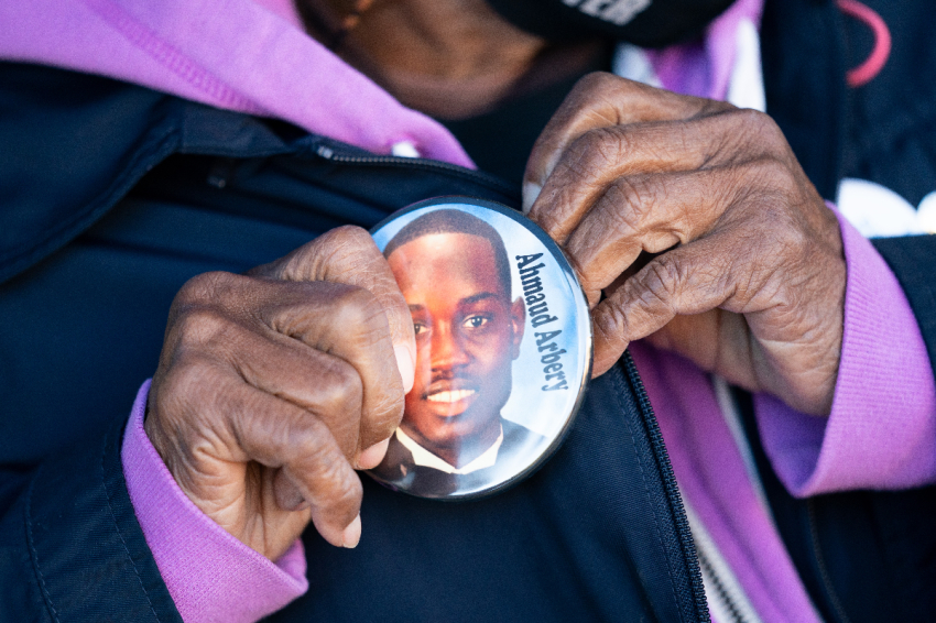 Annie Polite puts on a button for Ahmaud Arbery outside the Glynn County Courthouse as the jury deliberates in the trial of the killers of Ahmaud Arbery on November 24, 2021 in Brunswick, Georgia.