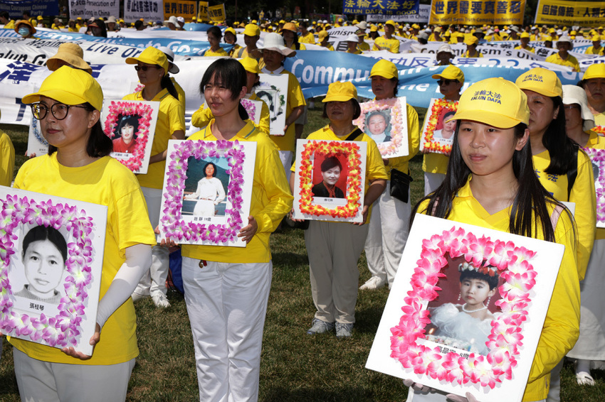 Falun Gong practitioners and supporters hold pictures of victims who were persecuted by the Chinese government as they take part in an annual rally and demonstration at the National Mall on July 16, 2021, in Washington, D.C. Members of Falun Gong held the event against the Chinese government’s persecution of the group and its practitioners.