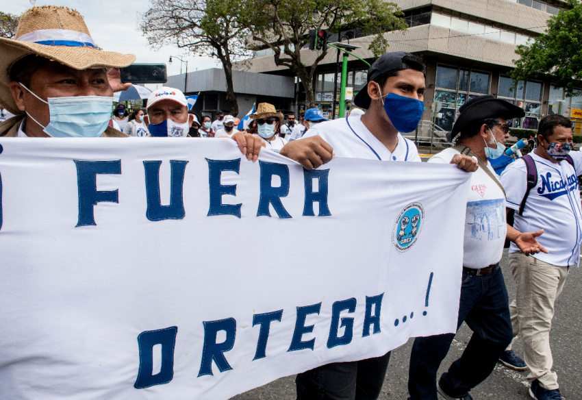 Nicaraguans living in Costa Rica carry a banner reading “Ortega Out” as they demonstrate in San Jose to commemorate the third anniversary of the beginning of the protests against the government of Nicaraguan President Daniel Ortega on April 18, 2021. Nicaragua’s political crisis erupted in April 2018, when protests mushroomed into a popular uprising that was met with a brutal crackdown in which hundreds were killed.