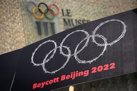 This photograph taken on June 23, 2021, shows a placard representing barber wire shaping and Olympics Rings are seen next to a sign of the Olympics Museum during a protest organised by Tibetan and Uyghur activists against Beijing 2022 Winter Olympics, in Lausanne as some 200 participants took part to the protest.