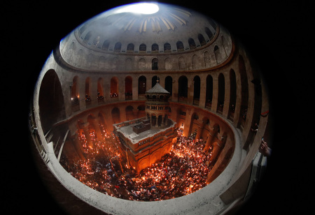 Christian Orthodox worshipers hold up candles lit from the Holy Fire as they gather in the Church of the Holy Sepulchre in Jerusalems Old City on April 27, 2019, during the Orthodox Easter. - The ceremony celebrated in the same way for eleven centuries, is marked by the appearance of "sacred fire" in the two cavities on either side of the Holy Sepulchre.