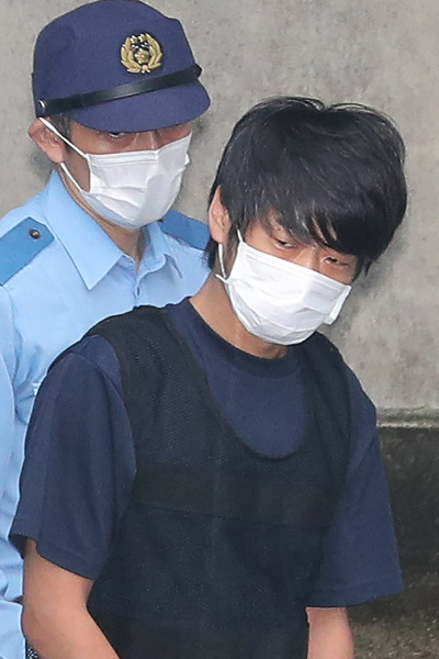 Tetsuya Yamagami (R), the man accused of murdering former Japanese Prime Minister Shinzo Abe, is escorted by police while leaving the Nara Nishi police station to head to the prosecutor's office in Nara on July 10, 2022.