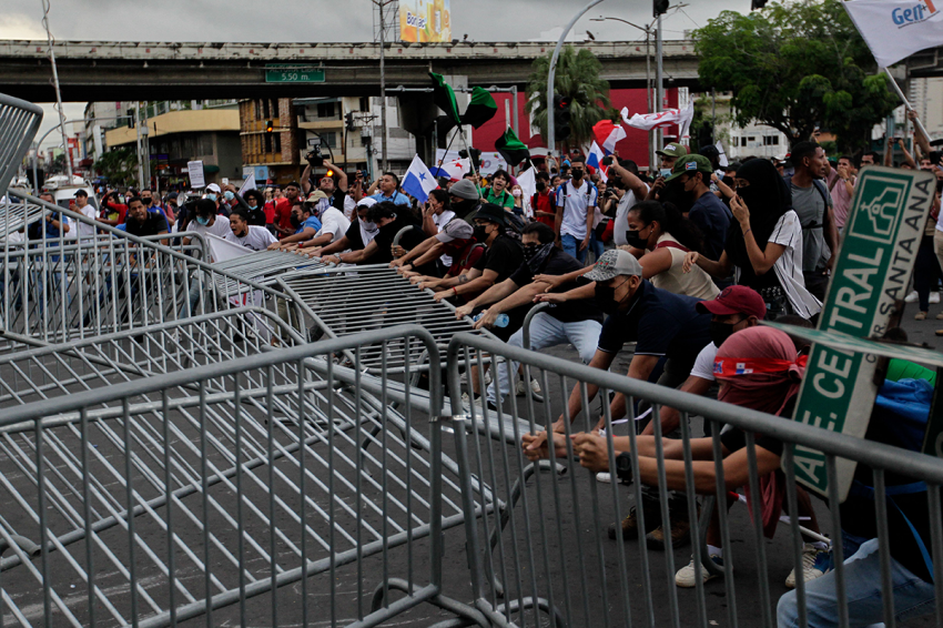 Protesters tear down a barrier during a march against the high cost of food and gasoline in Panama City, on July 12, 2022. - Despite the government's announcement on a solution to the population's petitions, thousands of people marched on Tuesday against rising product prices and corruption in Panama.