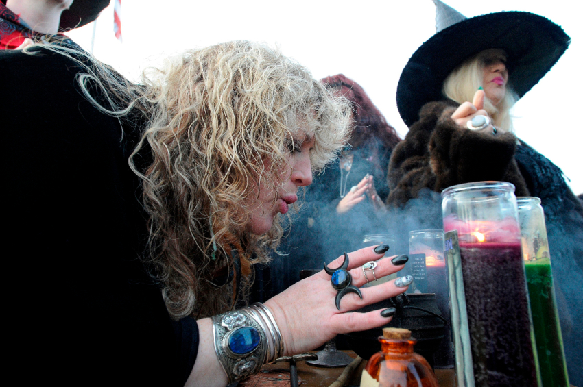 Salem Witch Sandra Wright blows in the fumes from the incense during the Salem Witches' Magic Circle at Salem Common on Halloween in Salem, MA on October 31, 2018. The ceremony involving local and visiting witches celebrates loved ones that have crossed over into the spirit world. The witches believe that on Halloween, the veil between the living and the dead is at its thinnest and connections can be made to those being mourned or missed.