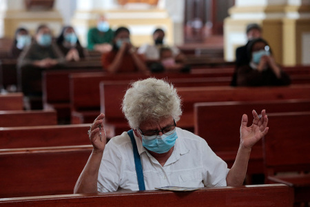 A woman prays during a mass at the Matagalpa Cathedral in Matagalpa, Nicaragua, on August 19, 2022. - Nicaraguan police forcefully removed Catholic bishop and government critic Rolando Alvarez from his official residence after two weeks under siege, said Catholic Church and rights groups who had no news on his whereabouts.