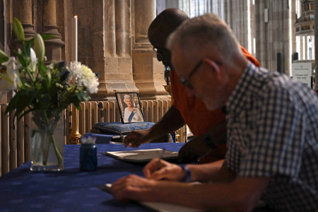 People sign books of condolence at Canterbury Cathedral, in south-east England on Sept. 11, 2022, as people of the Diocese and throughout the Communion express their affection and gratitude as they mourn the death of the late Britain's Queen Elizabeth II. - Queen Elizabeth II's coffin will travel by road through Scottish towns and villages on Sunday as it begins its final journey from her beloved Scottish retreat of Balmoral. The Queen, who died on Sept. 8, will be taken to the Palace of Holyroodhouse before lying at rest in St Giles' Cathedral, before travelling onwards to London for her funeral.