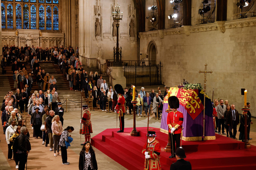 Members of the public pay their respects as they pass the coffin of Queen Elizabeth II as it Lies in State inside Westminster Hall, at the Palace of Westminster in London on September 15, 2022. - Queen Elizabeth II will lie in state in Westminster Hall inside the Palace of Westminster, until 0530 GMT on September 19, a few hours before her funeral, with huge queues expected to file past her coffin to pay their respects.